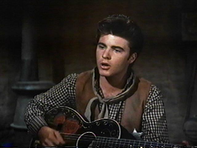 Ricky Nelson plays the guitar and sings backup